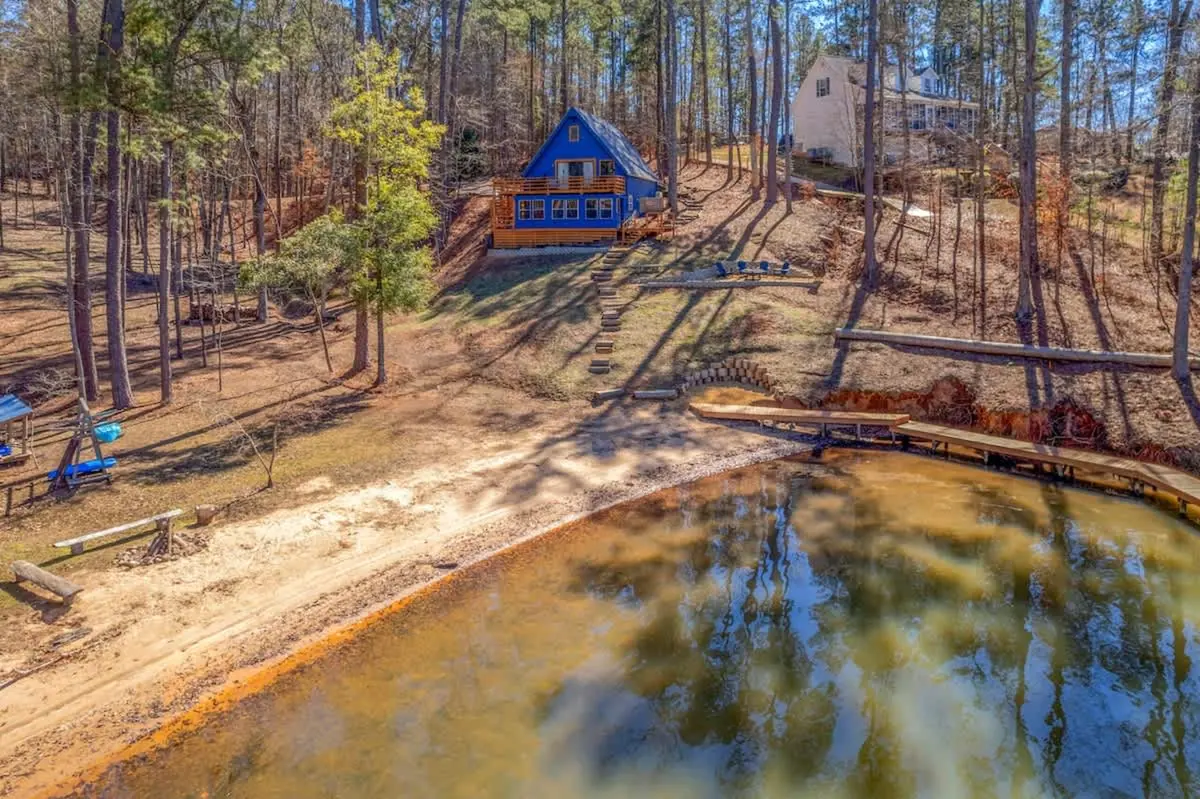 Aerial view of the wooded lot meeting the water in a quiet cove.