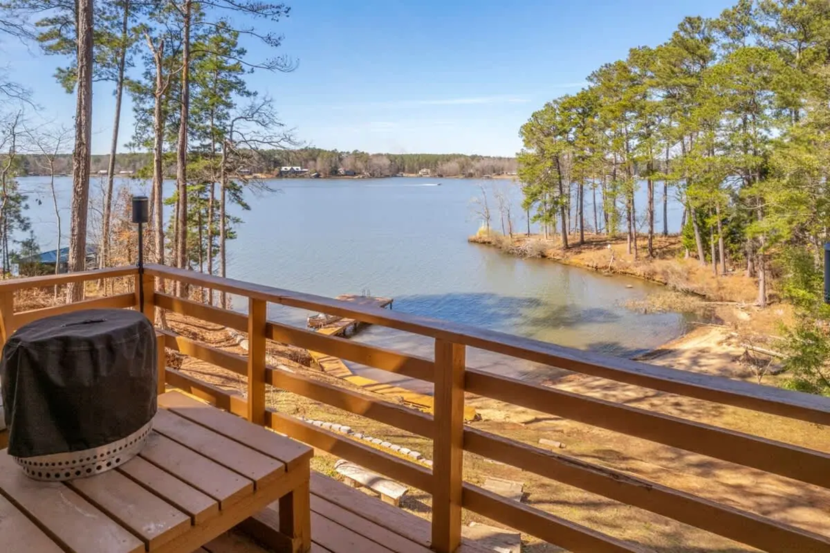 Covered grill and bench seating on the lakeside deck, water visible through the railing.