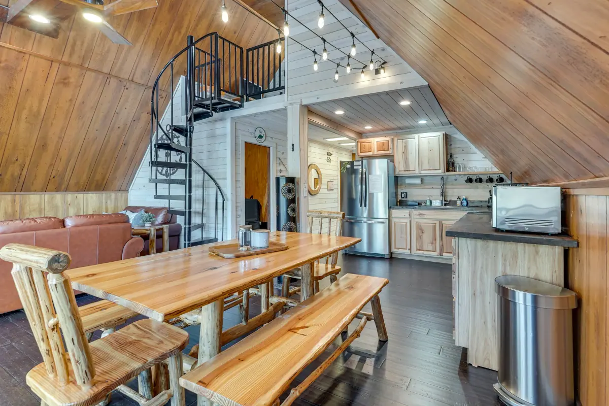Long timber dining table with bench seating, set below the loft and open to the kitchen.