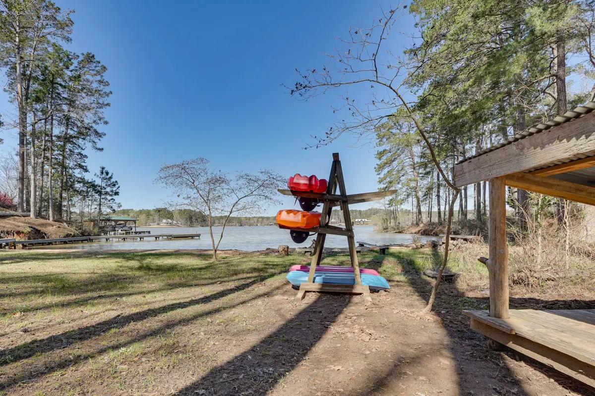 Kayak rack beside the shoreline holding several kayaks, with Lake Sinclair opening out behind.