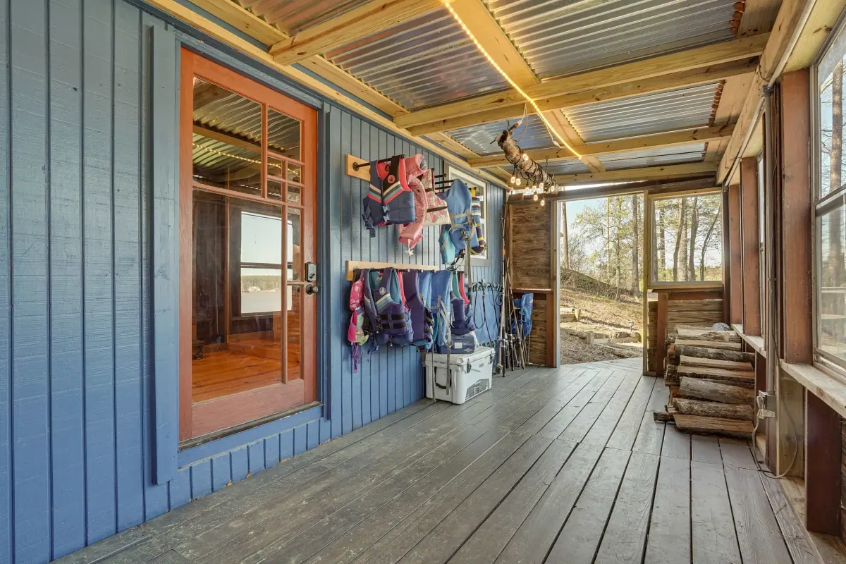 Covered porch running along the cabin, with life vests hanging ready by the door.