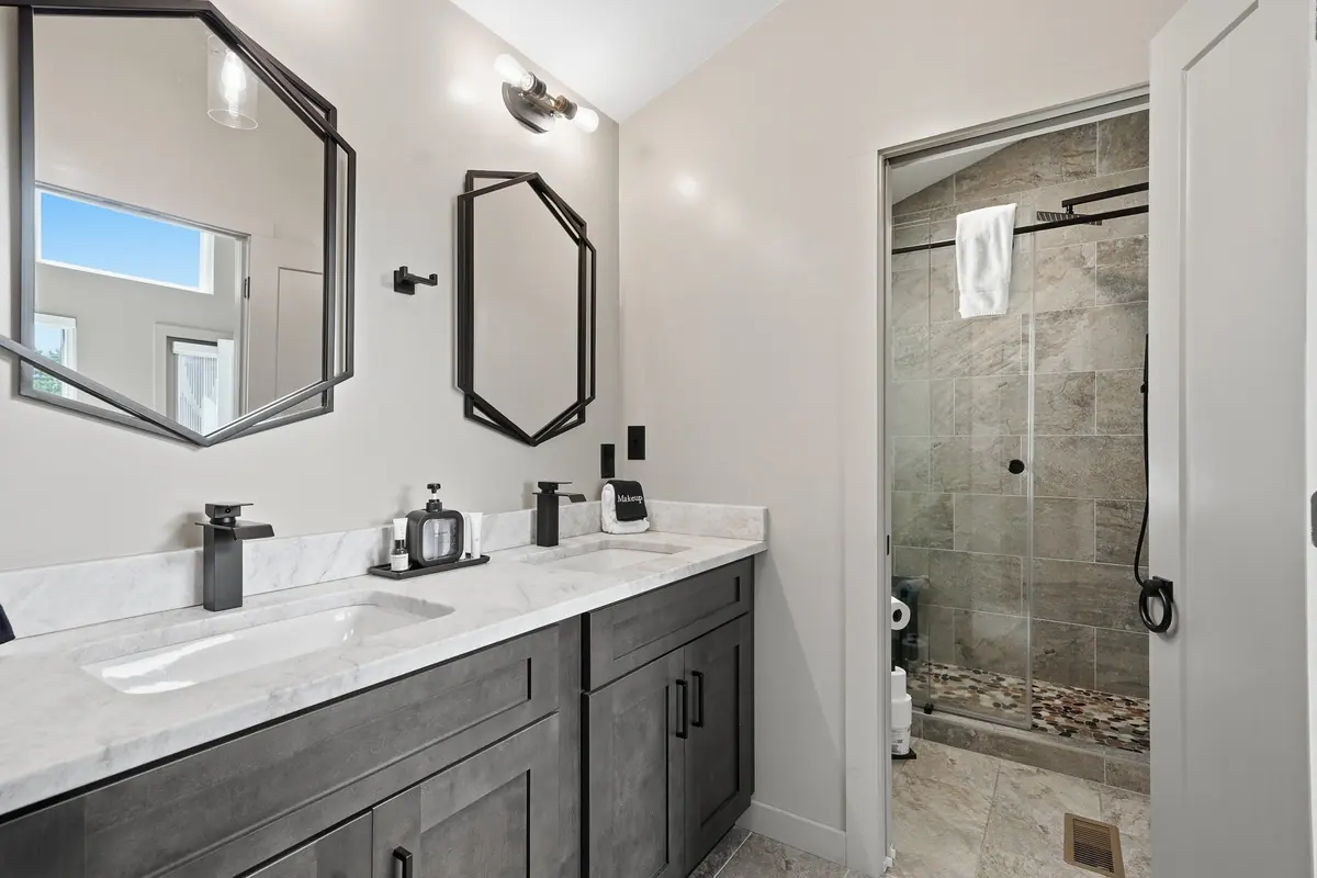 Bathroom with a double vanity, dark timber cabinetry and a glass walk-in shower.