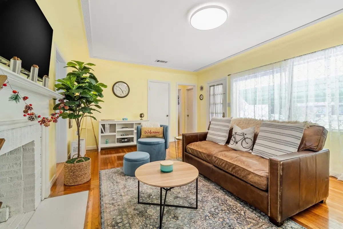 Second seating area with a leather sofa, round coffee table and built-in shelving beside the fireplace.